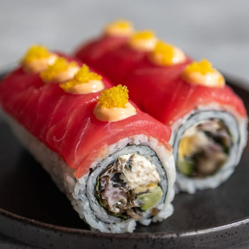 Two Iro Sushi "Stuff x Roll" sushi rolls, topped with tuna, sauce, and yellow caviar.
